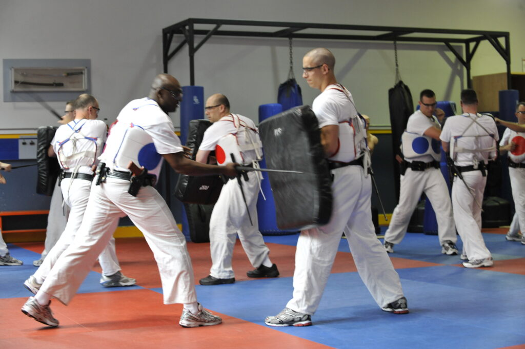 RCMP Cadets wear training attire and protective gear while simulating combat for training purposes.